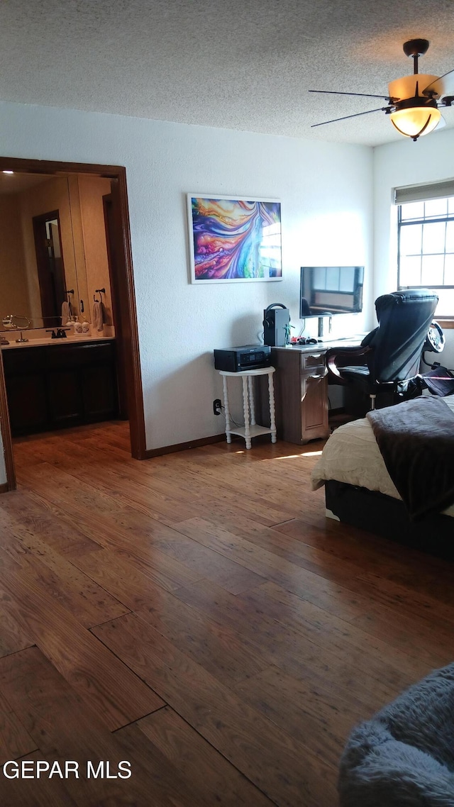 interior space with ceiling fan, a textured ceiling, and dark wood-type flooring