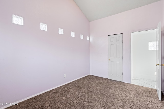 carpeted empty room with lofted ceiling