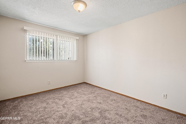 carpeted empty room featuring a textured ceiling