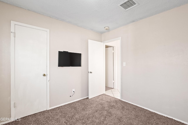 carpeted spare room with a textured ceiling