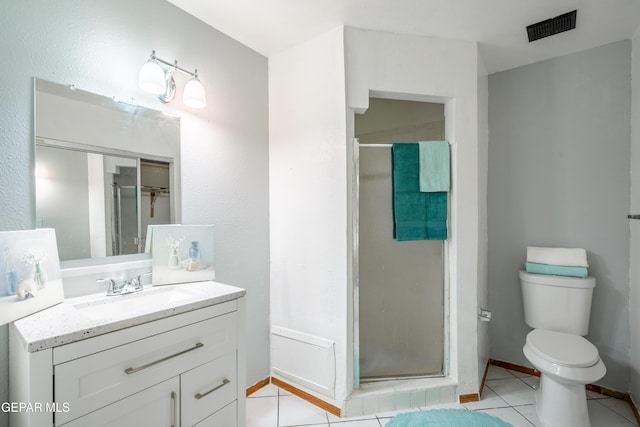 bathroom featuring tile patterned flooring, vanity, toilet, and a shower with door