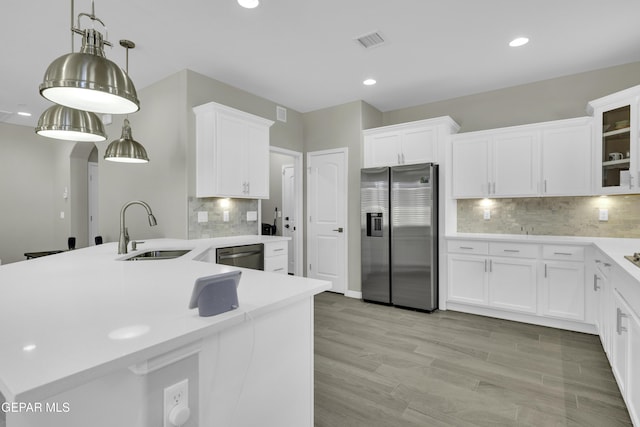 kitchen with white cabinetry, sink, stainless steel appliances, and decorative light fixtures