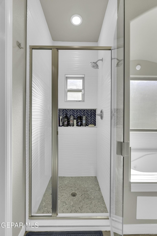 bathroom featuring a shower with door