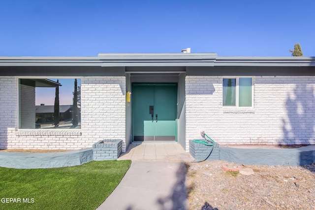 property entrance with a lawn