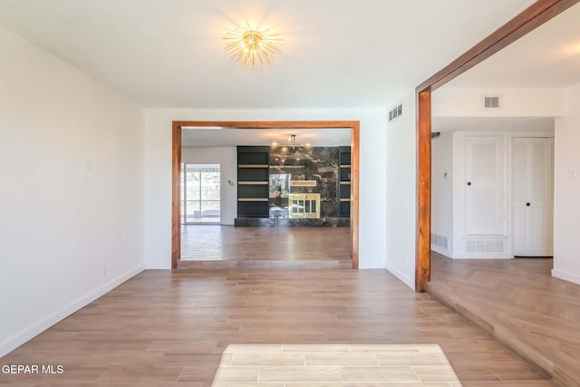 corridor with a notable chandelier and light hardwood / wood-style floors