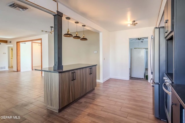 kitchen featuring pendant lighting, white fridge, and stainless steel refrigerator