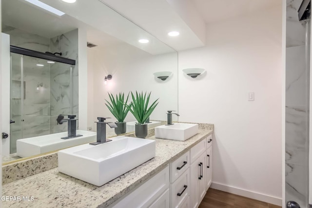 bathroom featuring walk in shower, vanity, and hardwood / wood-style flooring