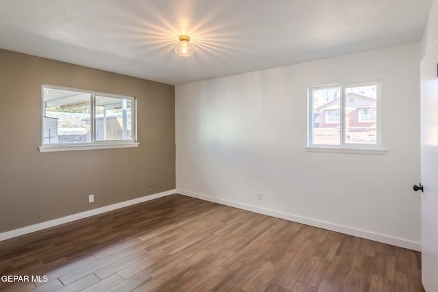 spare room with wood-type flooring and plenty of natural light