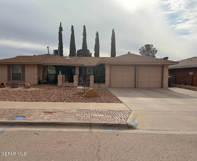 ranch-style home with central air condition unit and a garage