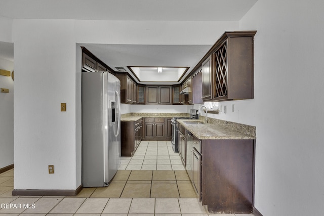 kitchen with sink, wall chimney exhaust hood, stainless steel appliances, dark brown cabinets, and light tile patterned floors