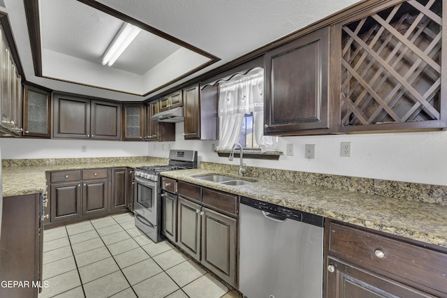 kitchen featuring dark brown cabinets, stainless steel appliances, light tile patterned floors, and sink