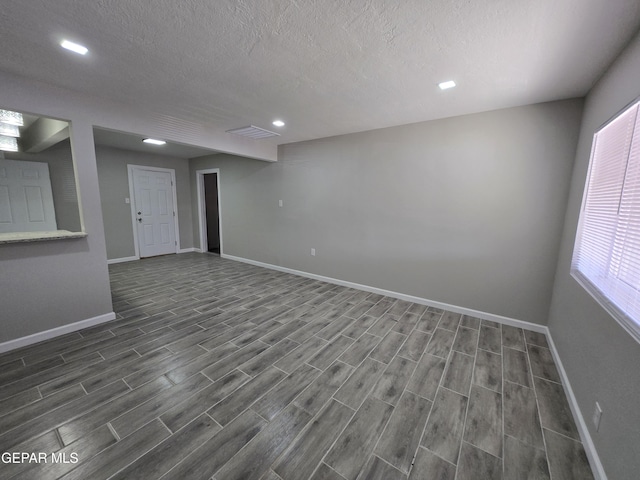 basement featuring dark hardwood / wood-style floors and a textured ceiling