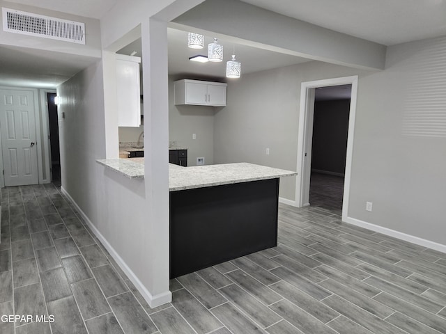 kitchen with pendant lighting, white cabinetry, and kitchen peninsula