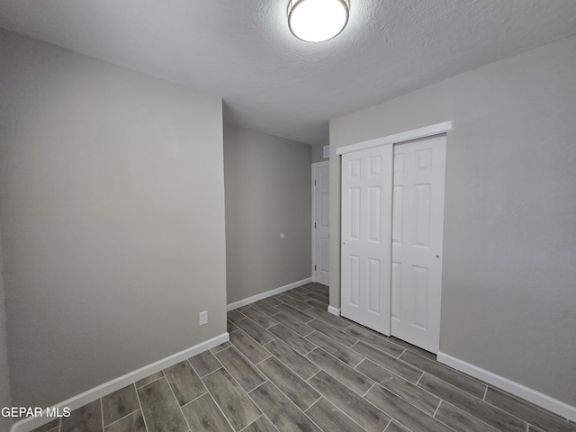 unfurnished bedroom featuring a textured ceiling and a closet