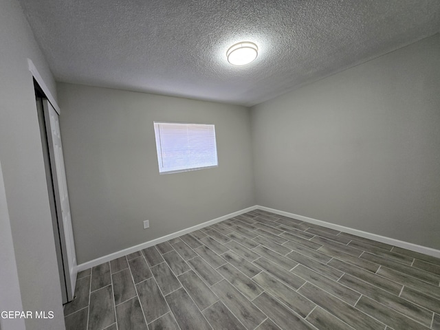 unfurnished room with hardwood / wood-style floors and a textured ceiling