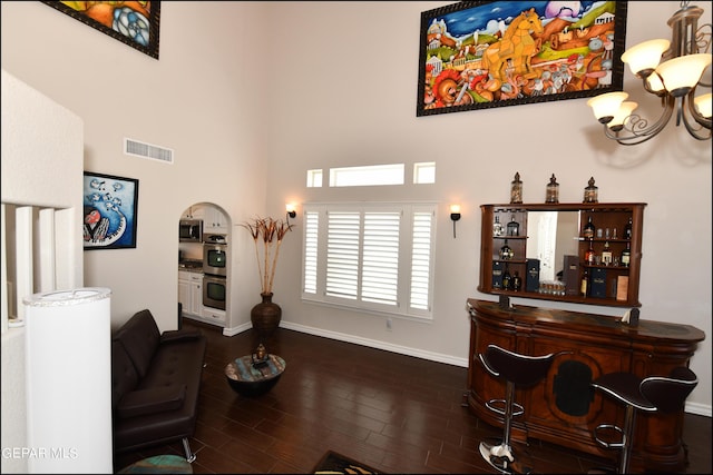 550 Shadow Willow Dr, El Paso, TX 79922 - living room featuring indoor bar, a towering ceiling, a chandelier, and dark wood-type flooring