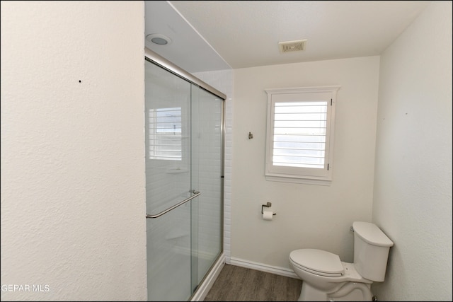 550 Shadow Willow Dr, El Paso, TX 79922 - bathroom featuring wood-type flooring, toilet, and a shower with shower door