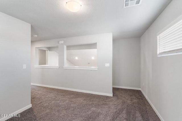 carpeted spare room featuring a textured ceiling