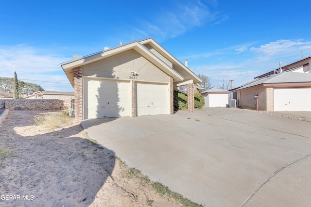 view of property exterior with cooling unit, an outdoor structure, and a garage