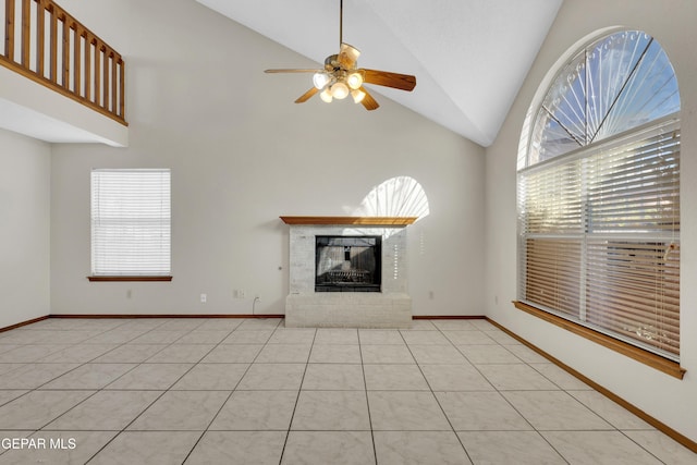 unfurnished living room with light tile patterned flooring, a healthy amount of sunlight, a fireplace, and vaulted ceiling