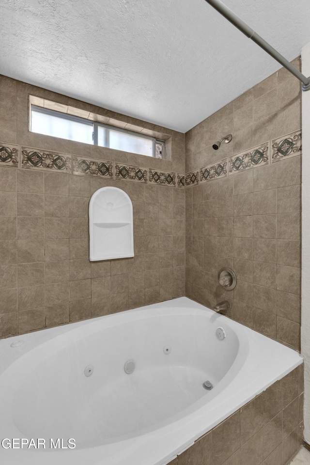 bathroom featuring a textured ceiling, tiled shower / bath combo, and plenty of natural light