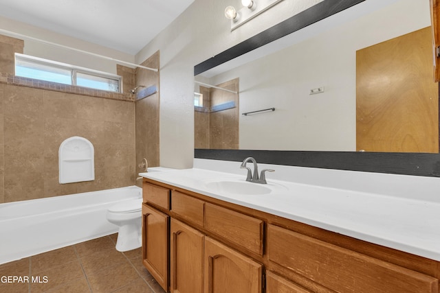 full bathroom with tile patterned floors, vanity, tiled shower / bath combo, and toilet