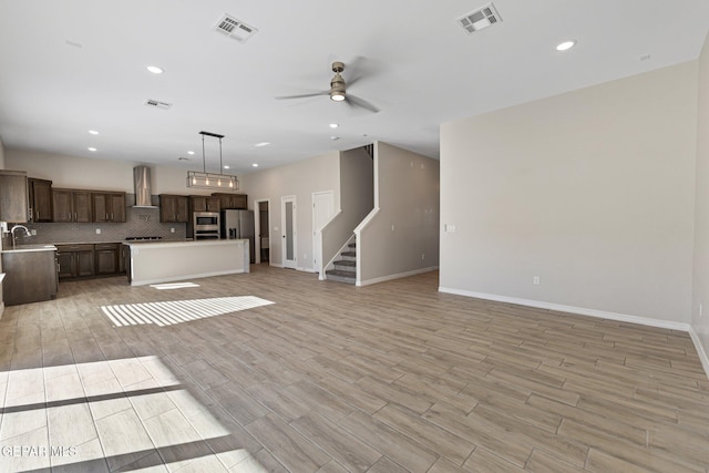 unfurnished living room with ceiling fan and sink