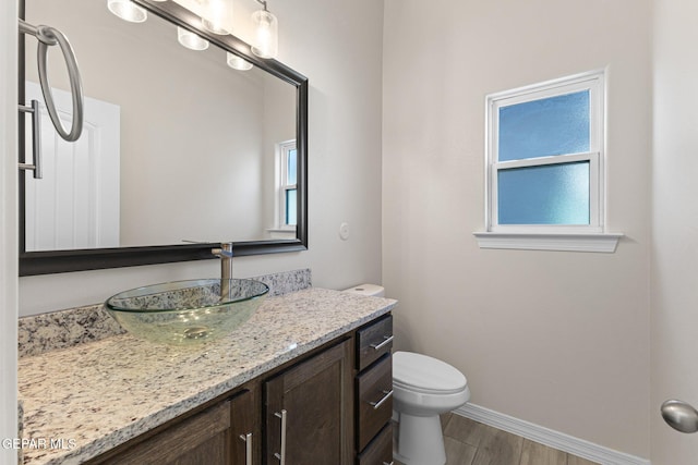 bathroom featuring wood-type flooring, vanity, and toilet