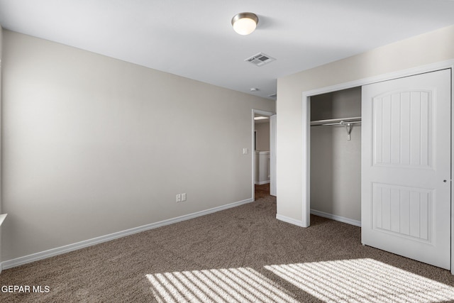 unfurnished bedroom with dark carpet and a closet