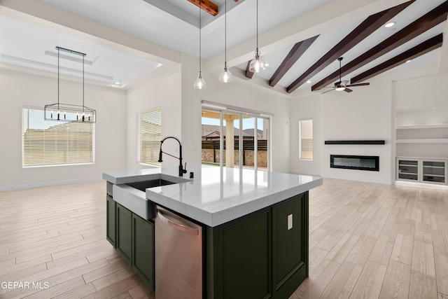 kitchen with pendant lighting, dishwasher, beam ceiling, and a kitchen island with sink