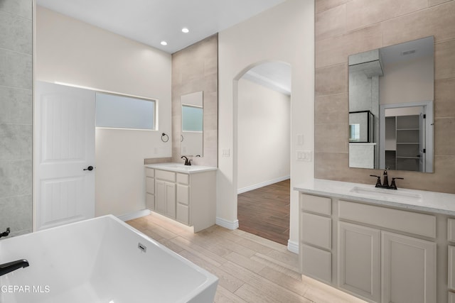 bathroom with a washtub and vanity