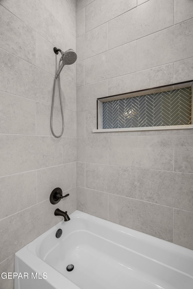 bathroom with tiled shower / bath combo