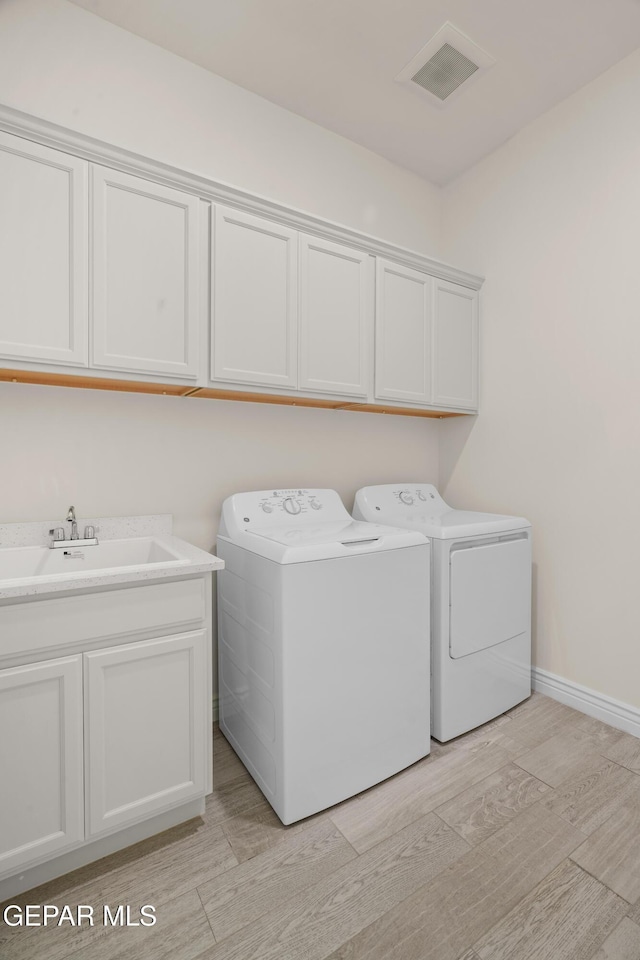 laundry area with cabinets, sink, and washing machine and clothes dryer