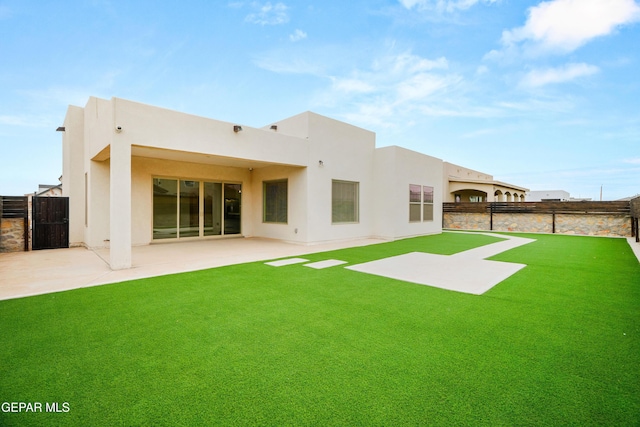 back of house with a patio and a lawn