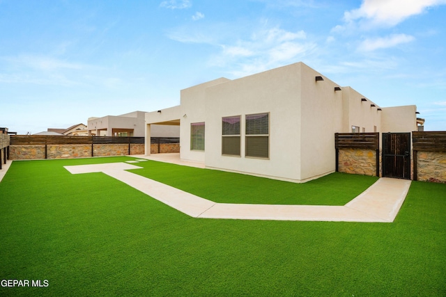 rear view of house featuring a lawn