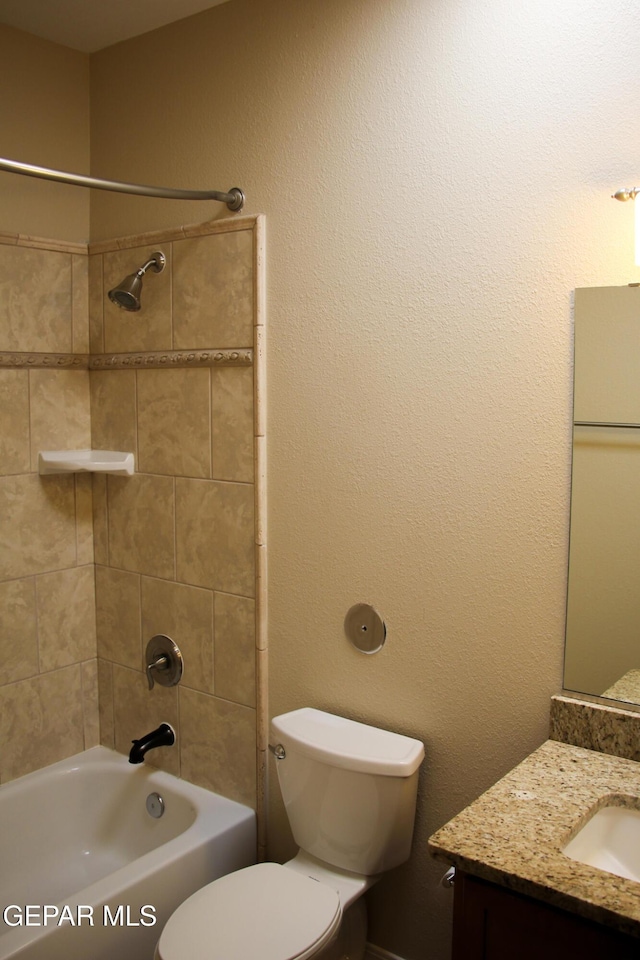 full bathroom featuring toilet, vanity, and tiled shower / bath