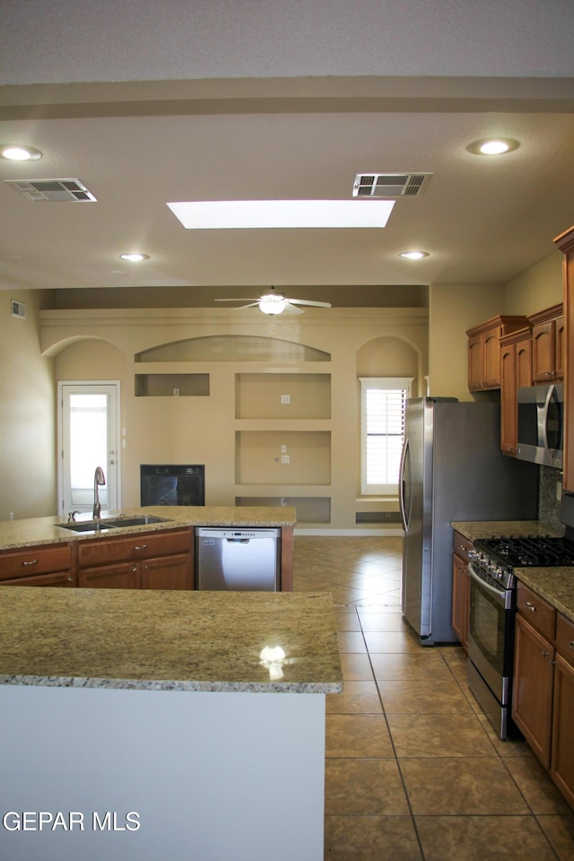 kitchen with tile patterned flooring, ceiling fan, sink, and stainless steel appliances