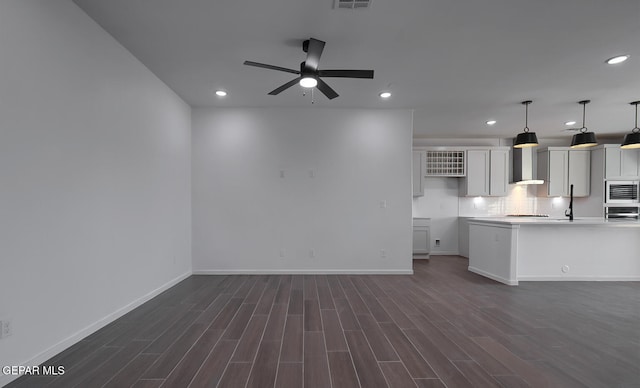 kitchen with recessed lighting, wall chimney exhaust hood, and dark wood-type flooring