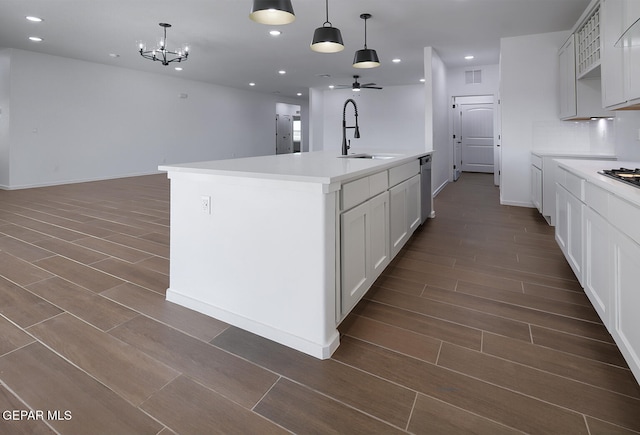 kitchen featuring dishwasher, open floor plan, dark wood-style flooring, and a sink