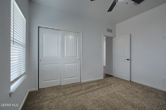 unfurnished bedroom with baseboards, a closet, visible vents, and carpet