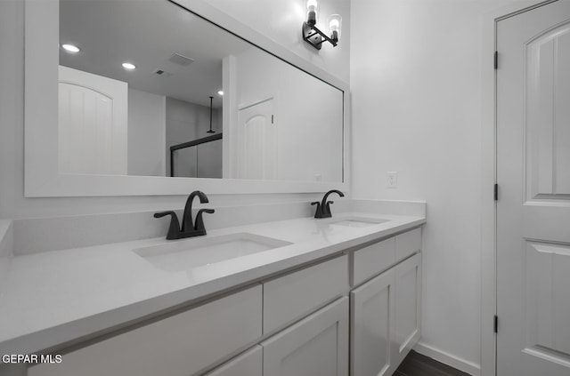 full bathroom featuring a shower stall, a sink, double vanity, and recessed lighting