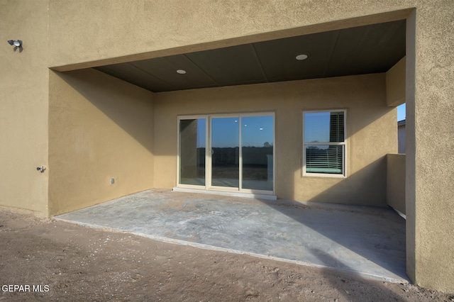 rear view of house with a patio and stucco siding