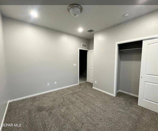 unfurnished bedroom with a closet and dark carpet