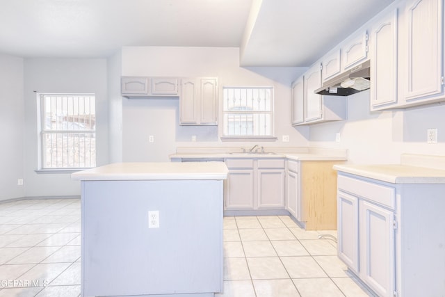 kitchen featuring light tile patterned floors, a kitchen island, and sink