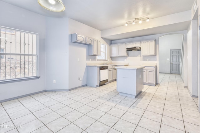 kitchen featuring gray cabinetry, dishwasher, a kitchen island, and light tile patterned flooring