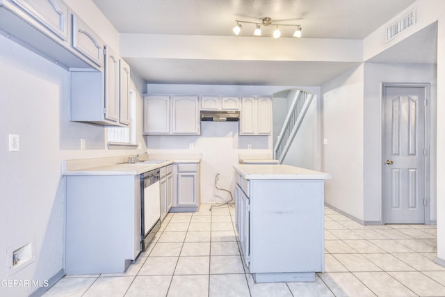 kitchen featuring dishwashing machine, light tile patterned floors, and sink