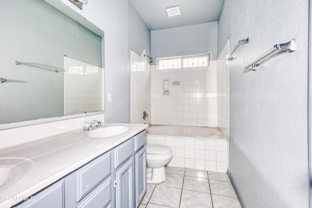 full bathroom featuring tile patterned floors, tiled shower / bath, vanity, and toilet