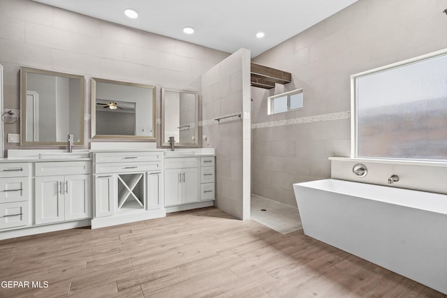 bathroom with vanity, separate shower and tub, tile walls, and ceiling fan