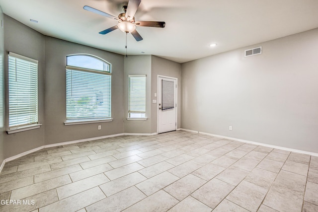 tiled spare room featuring ceiling fan