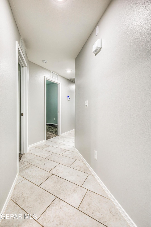 hall with light tile patterned floors